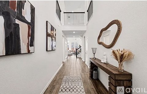 A hallway with a wooden bench and a mirror on the wall.