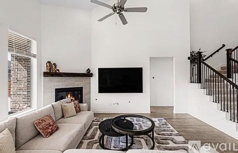 A living room with a couch, a fireplace, a television, and a coffee table.