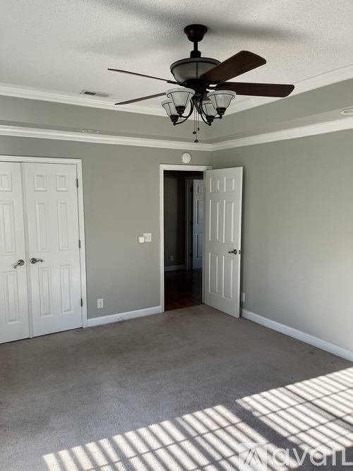 A room with a ceiling fan and two doors.