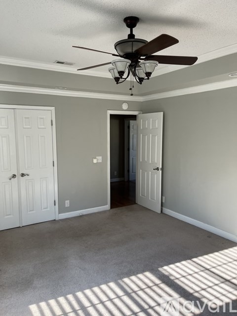 A room with a ceiling fan and two doors.