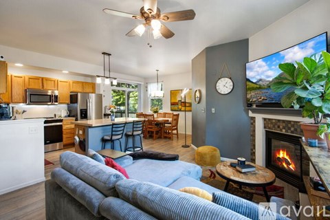 A living room with a grey couch and a fireplace.