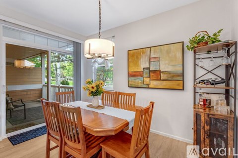 A dining room with a wooden table and chairs.