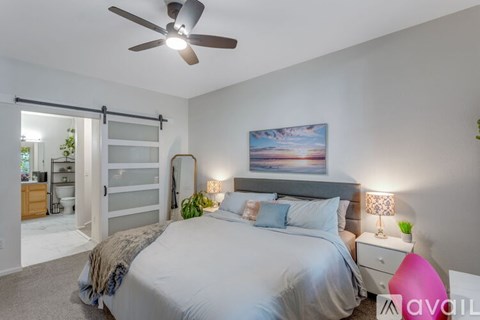 A bedroom with a large bed and a ceiling fan.