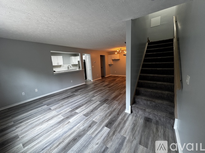 A spacious room with a staircase leading to another floor.