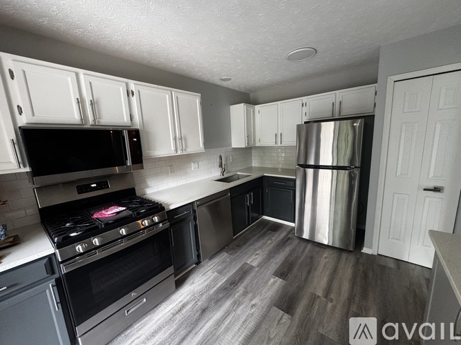 A kitchen with a stove top oven and a refrigerator.