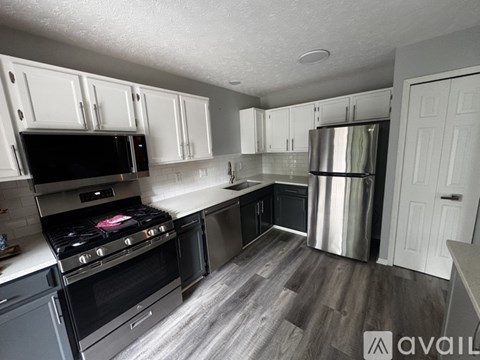 A kitchen with a stove top oven and a refrigerator.