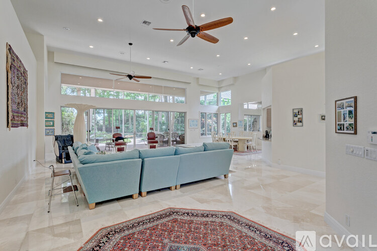 A living room with a blue couch and a fan.