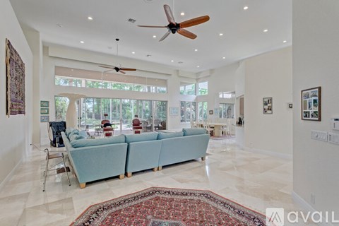 A living room with a blue couch and a fan.