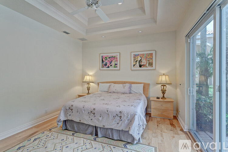 A bedroom with a large bed and two lamps.