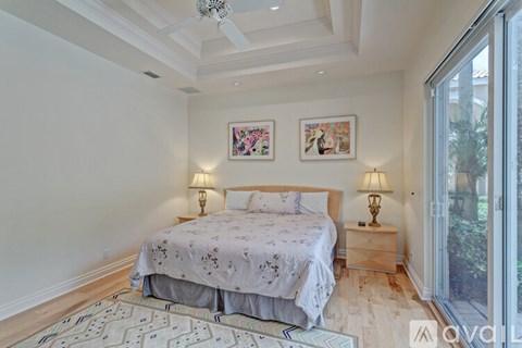 A bedroom with a large bed and two lamps.