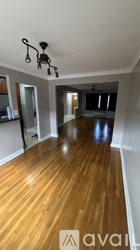 A room with wooden floors and a chandelier.