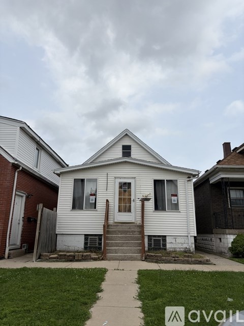 A white house with a brown door and a small porch.
