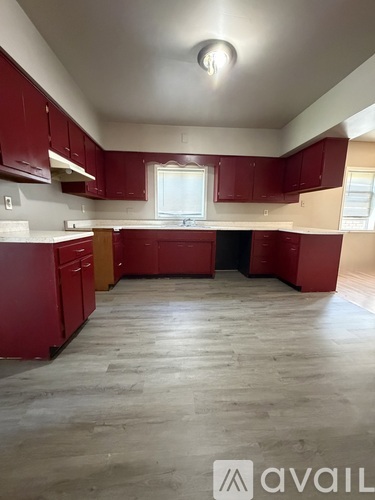 A kitchen with red cabinets and a window.