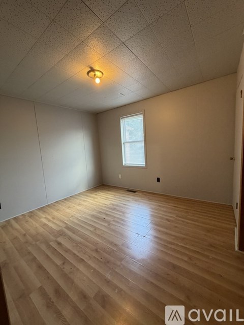 A room with wooden flooring and a window.