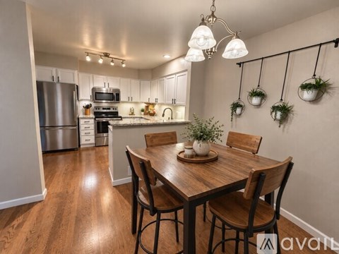 A kitchen with a wooden table and chairs.