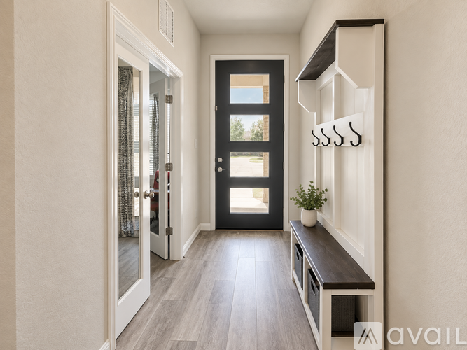 A hallway with a bench and a door.