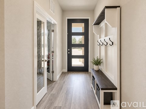 A hallway with a bench and a door.