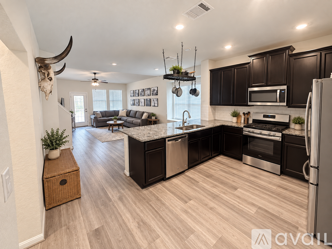A modern kitchen with dark wood cabinets and stainless steel appliances.