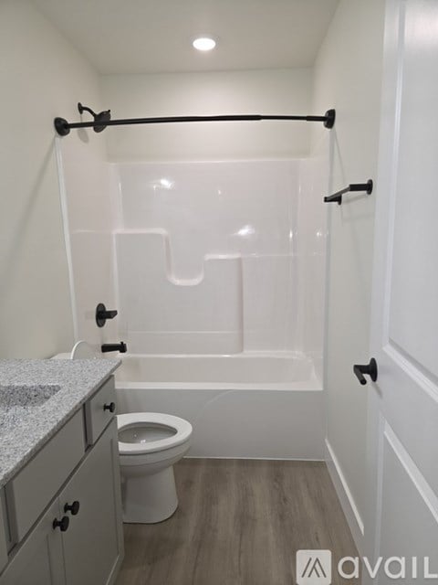 A bathroom with a toilet, a bathtub, and a counter.