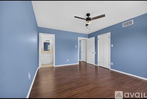 A room with blue walls and a ceiling fan.