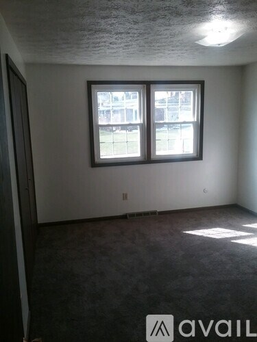 A room with a carpeted floor and a window.