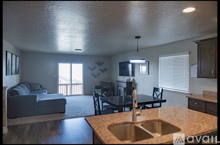 A kitchen with a sink and a dining table with chairs.