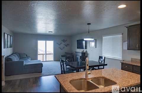A kitchen with a sink and a dining table with chairs.
