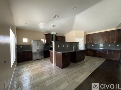 A spacious kitchen with dark wood cabinets and a central island.