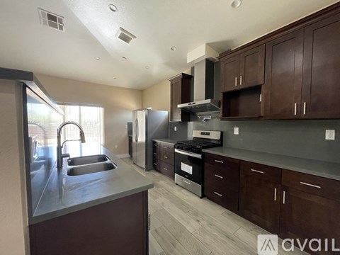 A kitchen with brown cabinets and a stainless steel sink.
