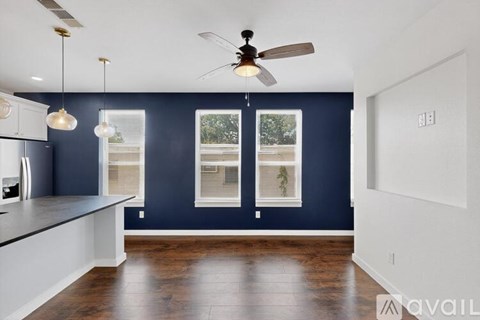 A kitchen with a ceiling fan and pendant lights.