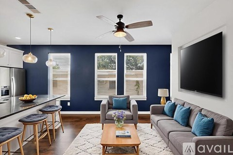 A living room with a grey couch and a ceiling fan.