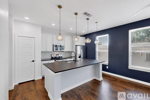 A kitchen with a black countertop and white cabinets.