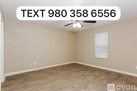 A room with a ceiling fan and a window with blinds.