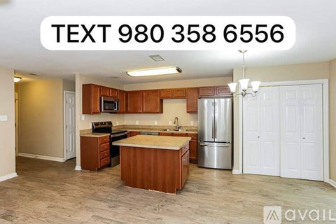 A kitchen with a refrigerator, sink, and cabinets is available for rent.