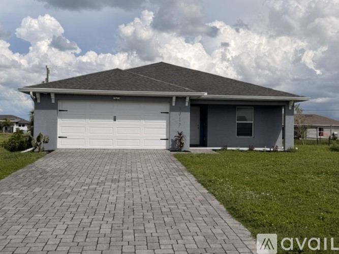 A house with a grey roof and a white garage door.