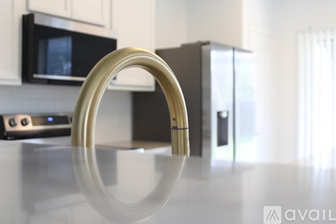 A kitchen with a black microwave and a silver refrigerator.
