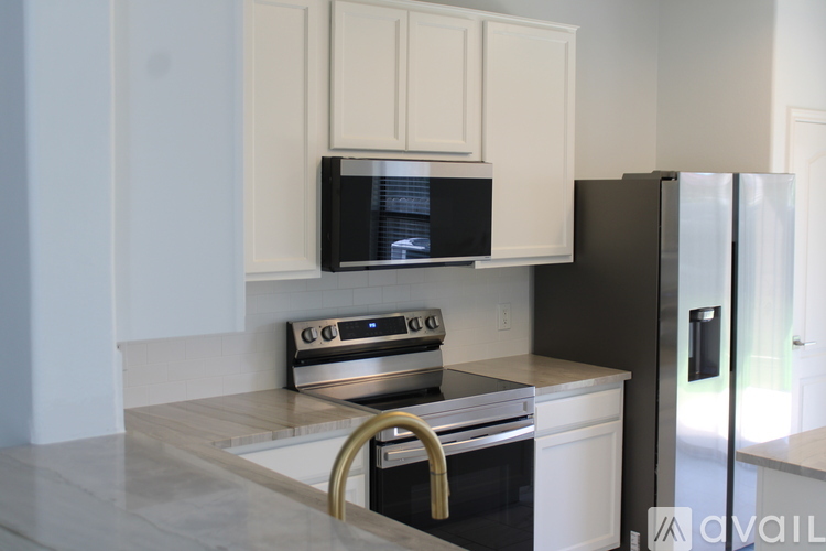 A kitchen with a black fridge and a black microwave.