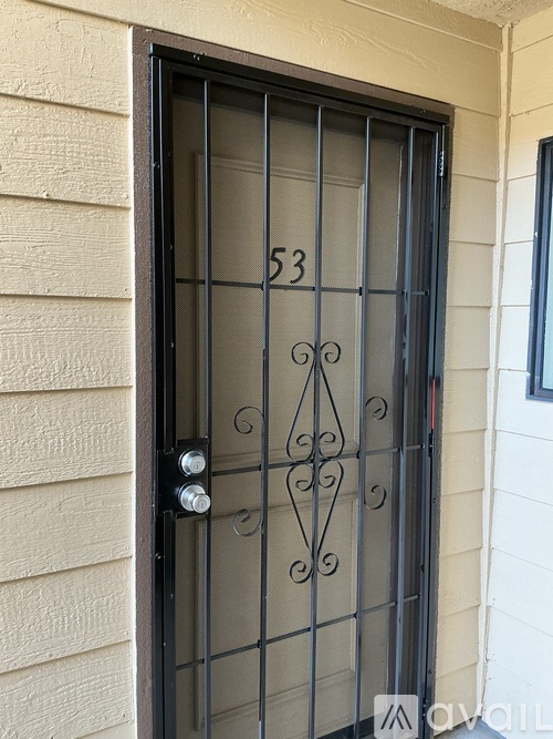A black wrought iron door with the number 53 on it.