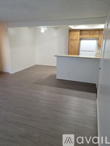 A room with wooden flooring and a window with wooden blinds.