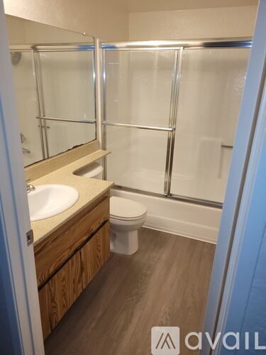 A bathroom with a toilet, sink and mirror.