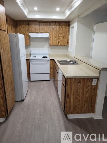 A kitchen with wooden cabinets and a white fridge.