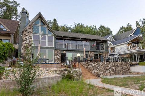 A modern house with a stone wall and a flag on the porch.