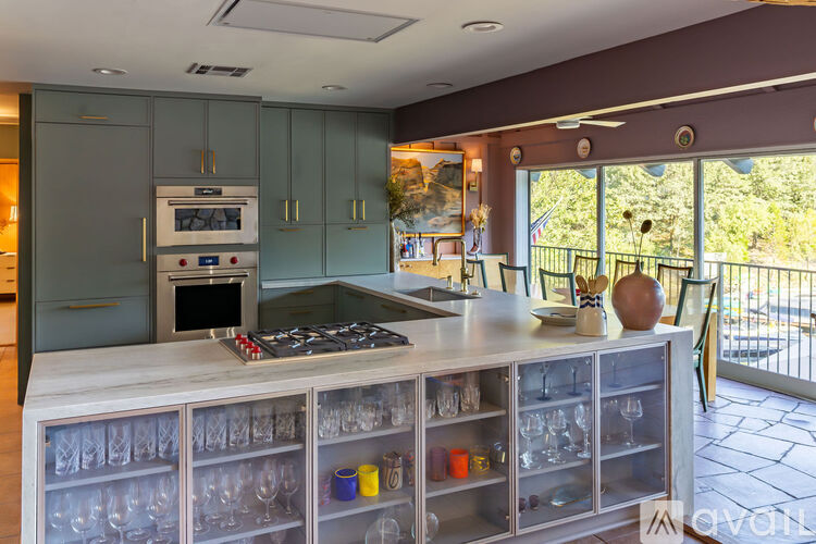 A kitchen with a stove top oven and a glass cabinet.