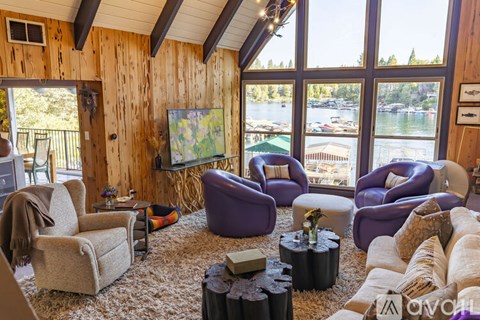 A living room with purple chairs and a wooden wall.