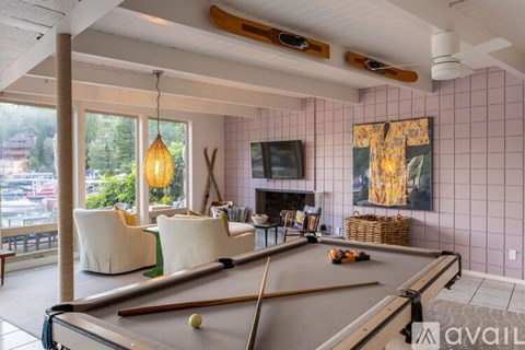 A room with a pool table and a fireplace.