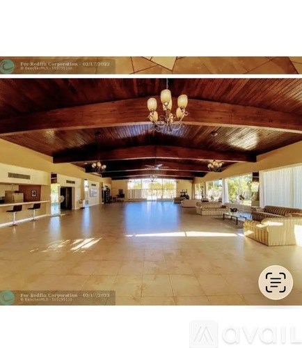 A spacious room with wooden ceilings and a chandelier.
