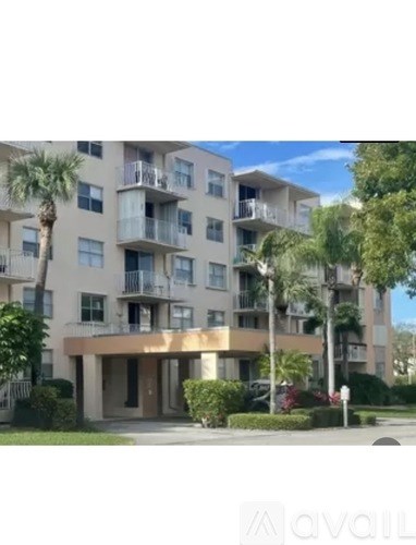 A building with balconies and a palm tree in front.