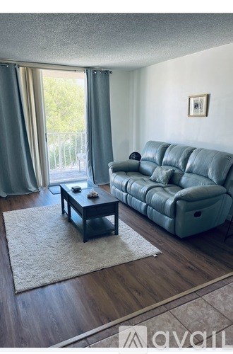 A living room with a grey leather couch and a coffee table.
