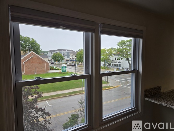 A window with a view of a street and buildings outside.