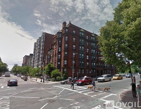 A street view with cars, pedestrians, and buildings.